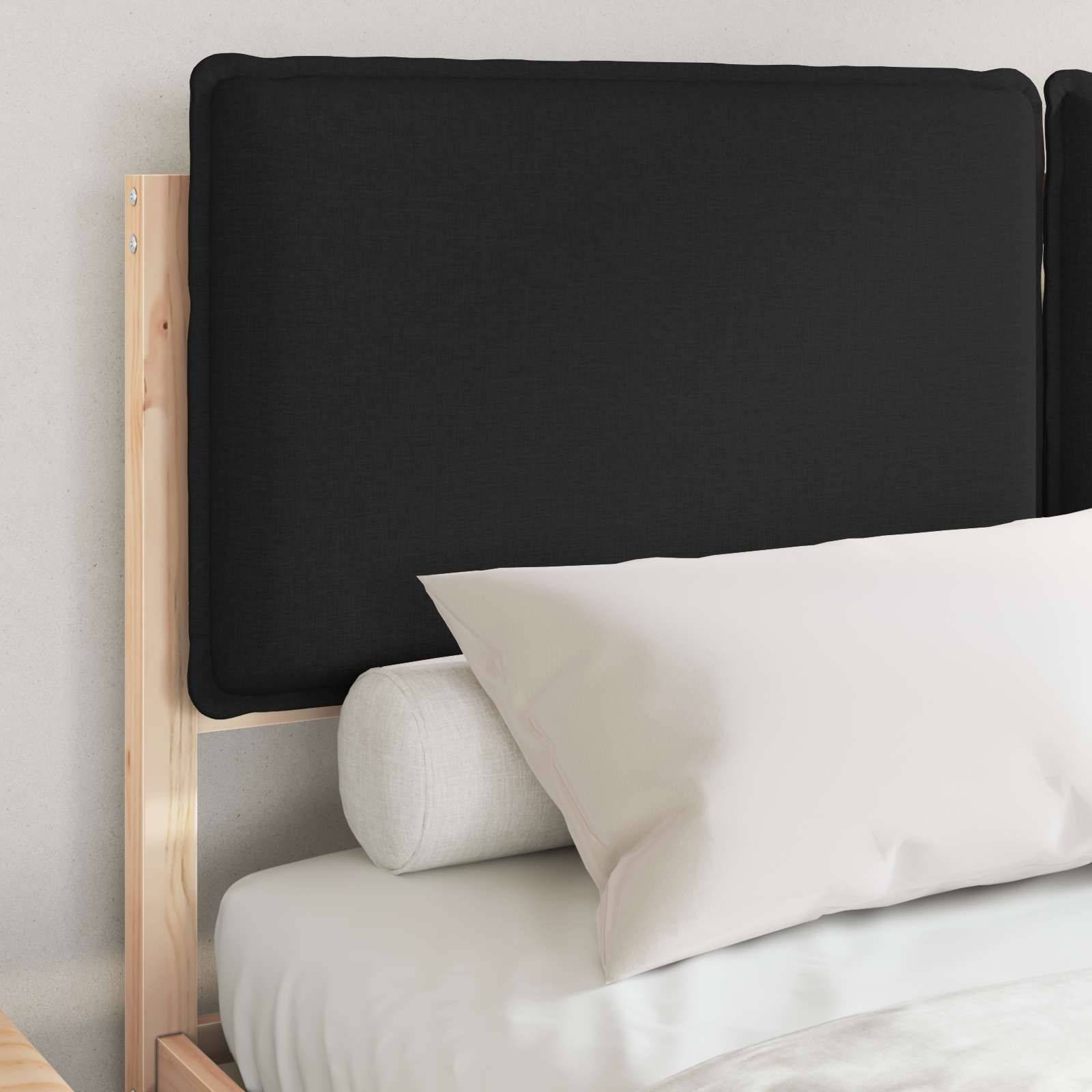 Ein sauber gemachtes Bett mit einem Rahmen aus hellem Holz, einem schwarzen Kopfteil, weißem Kissen und weißer Bettwäsche, in einer minimalistischen Schlafzimmerumgebung.