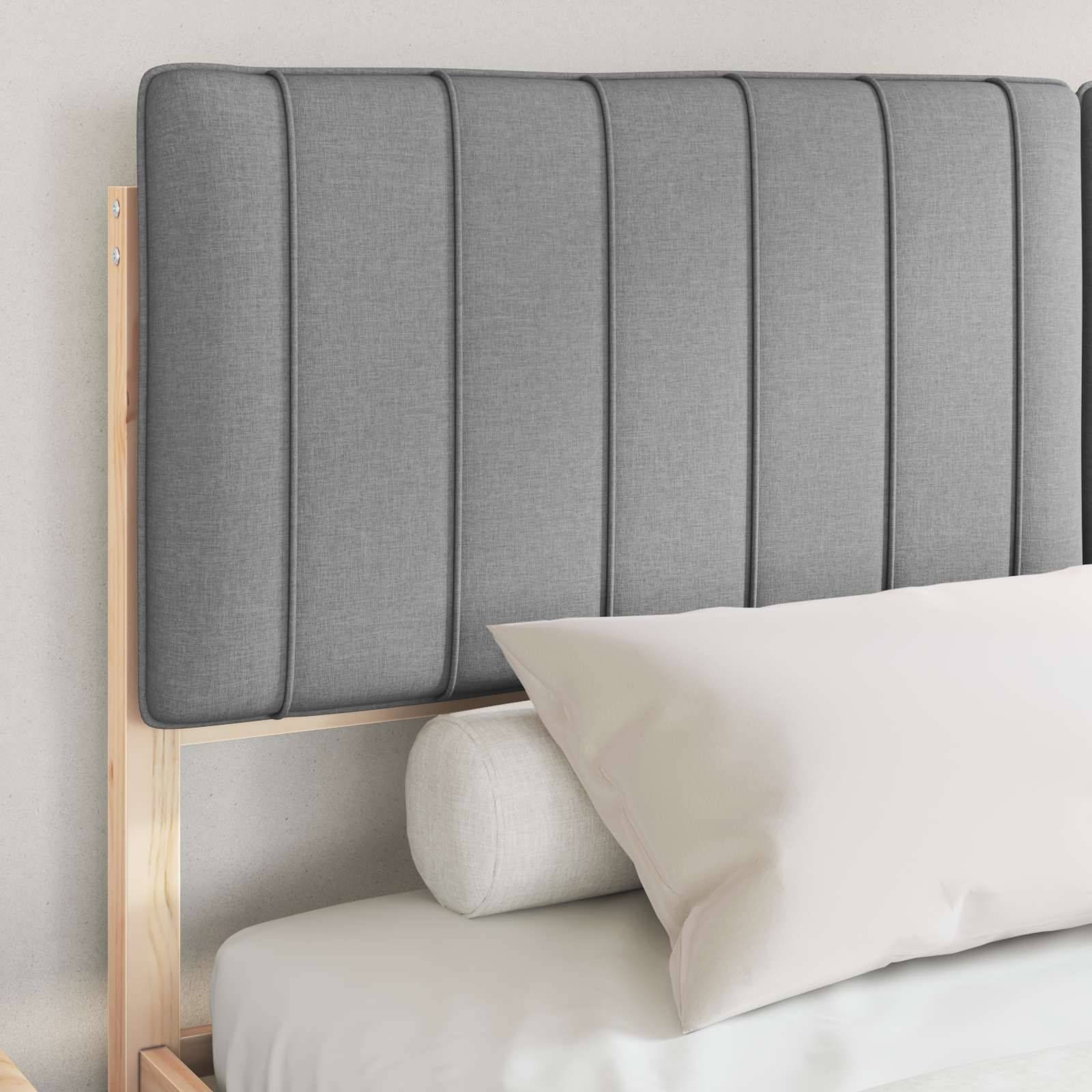Ein sauber gemachtes Bett mit einem grauen, gepolsterten Kopfteil und weißer Bettwäsche in einem minimalistischen Schlafzimmerambiente.