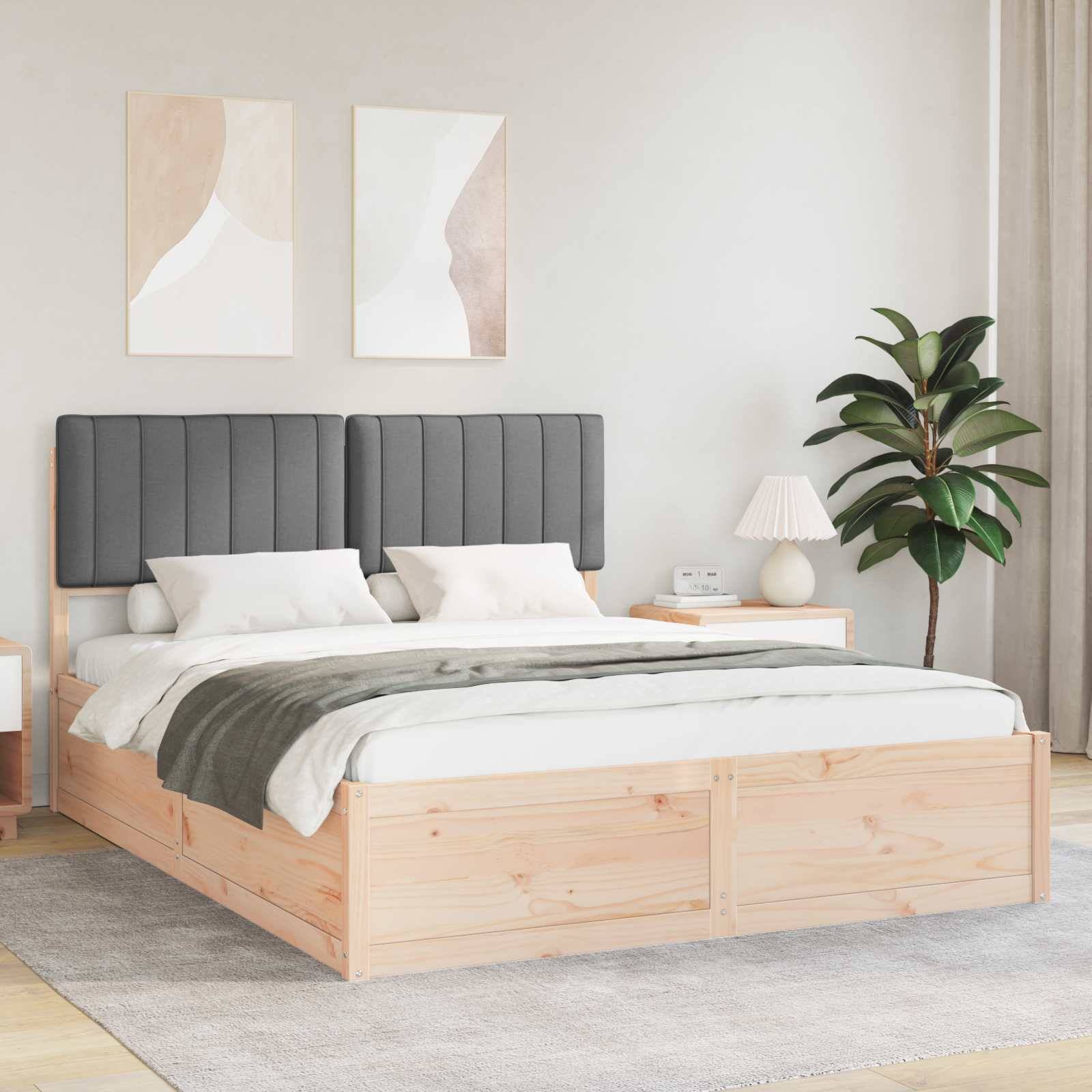Ein modernes Schlafzimmer zeigt ein großes Holzbett mit gepolstertem Kopfteil, weißer Bettwäsche und dekorativen Kissen. Ein Nachttisch trägt eine Lampe und Bücher.