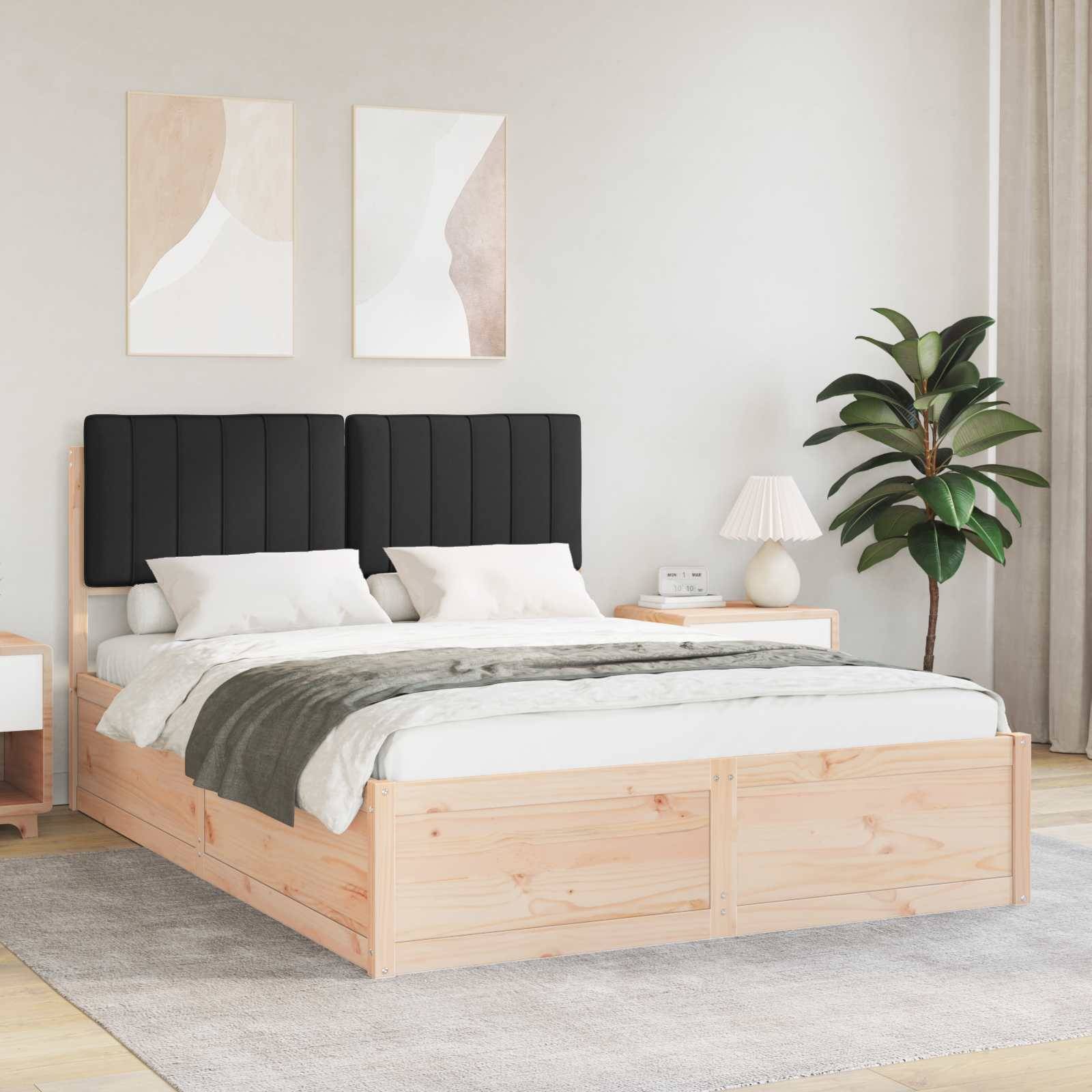 Ein modernes Schlafzimmer mit einem Holzbett, das einen schwarzen gepolsterten Kopfteil aufweist, weiße Bettwäsche, Nachttische mit Lampen und abstrakte Wandkunst.