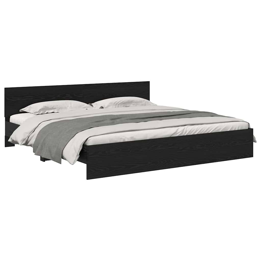 Ein minimalistisches schwarzes Plattformbett mit Kopfteil, bezogen mit weißer Bettwäsche und einer grauen Decke.