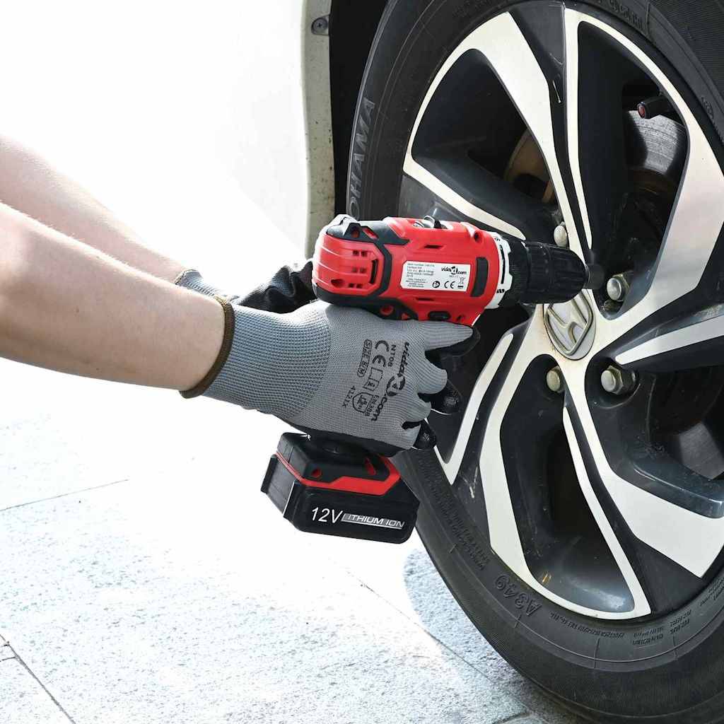 Eine Person verwendet eine rote Bohrmaschine, um eine Schraube an einem Autoreifen zu befestigen und damit eine Wartungsaufgabe am Fahrzeug zu demonstrieren.