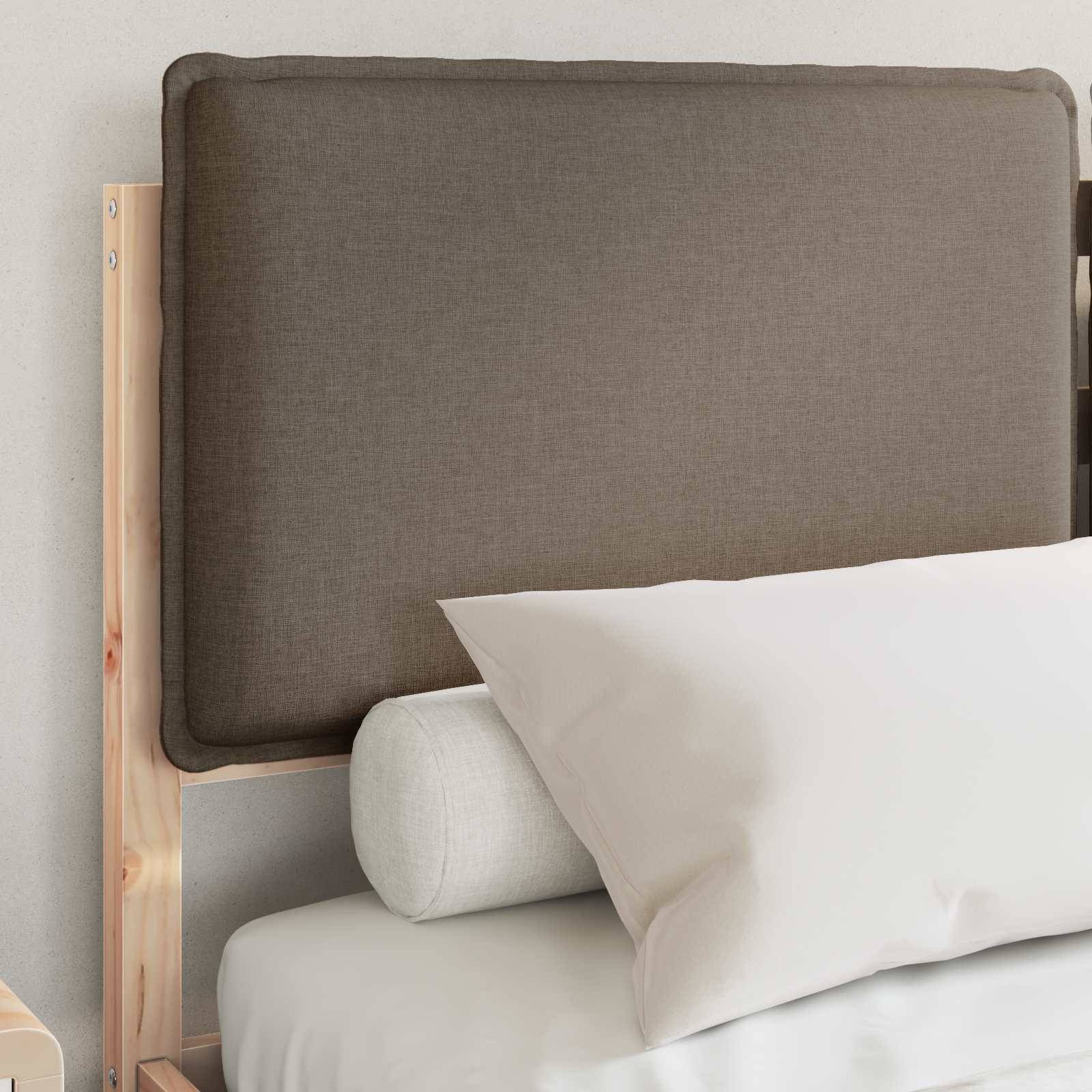 Ein Bett mit einem Holzrahmen verfügt über einen braun gepolsterten Kopfteil, ein weißes Kissen und ein zylindrisches Nackenrolle.