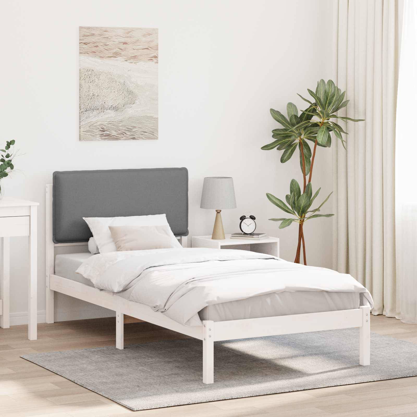 Minimalistisches Schlafzimmer mit einem Bett mit weißem Rahmen, grauem Kopfteil und heller Bettwäsche. Ausgestattet mit einer Topfpflanze, einem Nachttisch und Wandkunst.