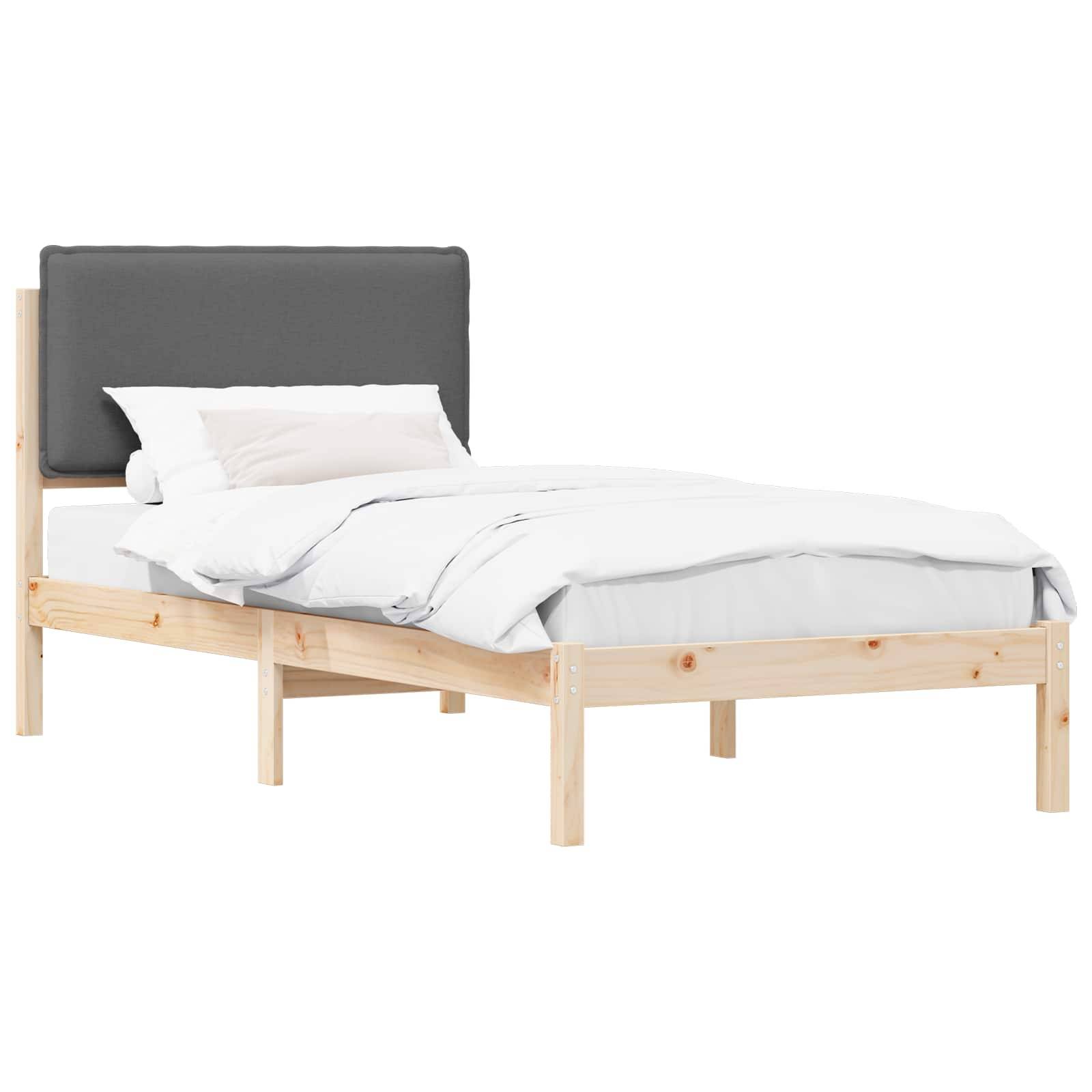 Ein Holzbettgestell mit einem grau gepolsterten Kopfteil, ausgestattet mit weißer Bettwäsche und einem Kissen, vor einem einfachen Hintergrund präsentiert.