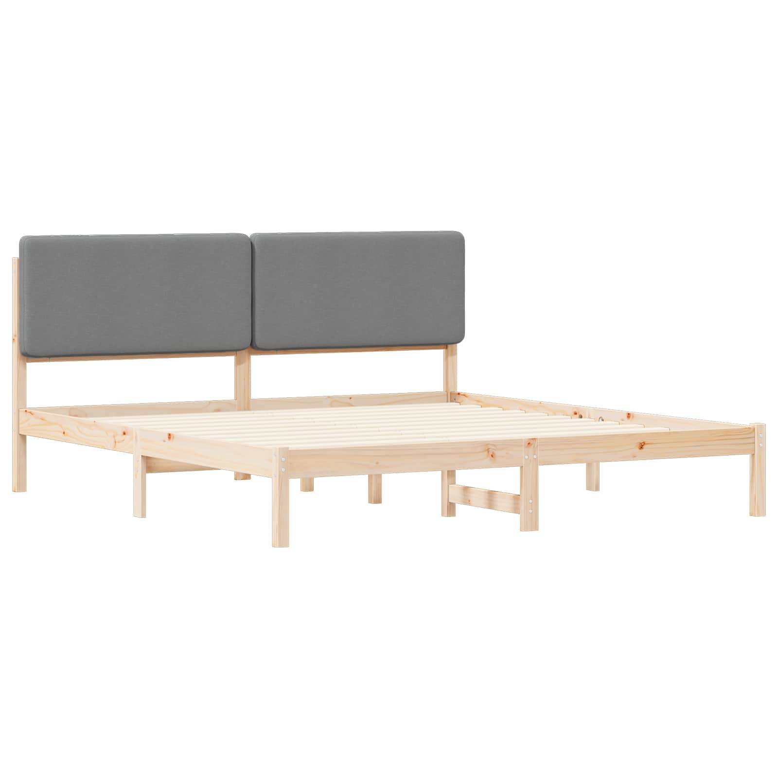 Ein Holzbettgestell mit Lattenrost und zwei grauen gepolsterten Kopfteilen, schräg von der Seite auf weißem Hintergrund dargestellt.