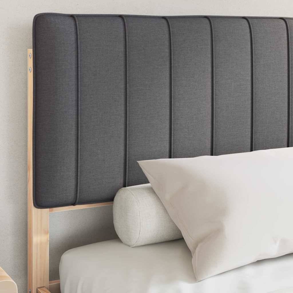 Grauer gepolsterter Kopfteil mit vertikalem Paneeldesign, sichtbarer Holzbettrahmen, hellfarbiges Kissen und rundes Kissen auf einer weißen Matratze.