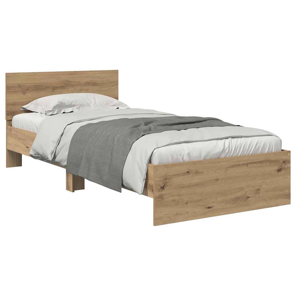 Ein Holz-Doppelbett mit einem schlichten Kopf- und Fußteil, bezogen mit weißer und grauer Bettwäsche.