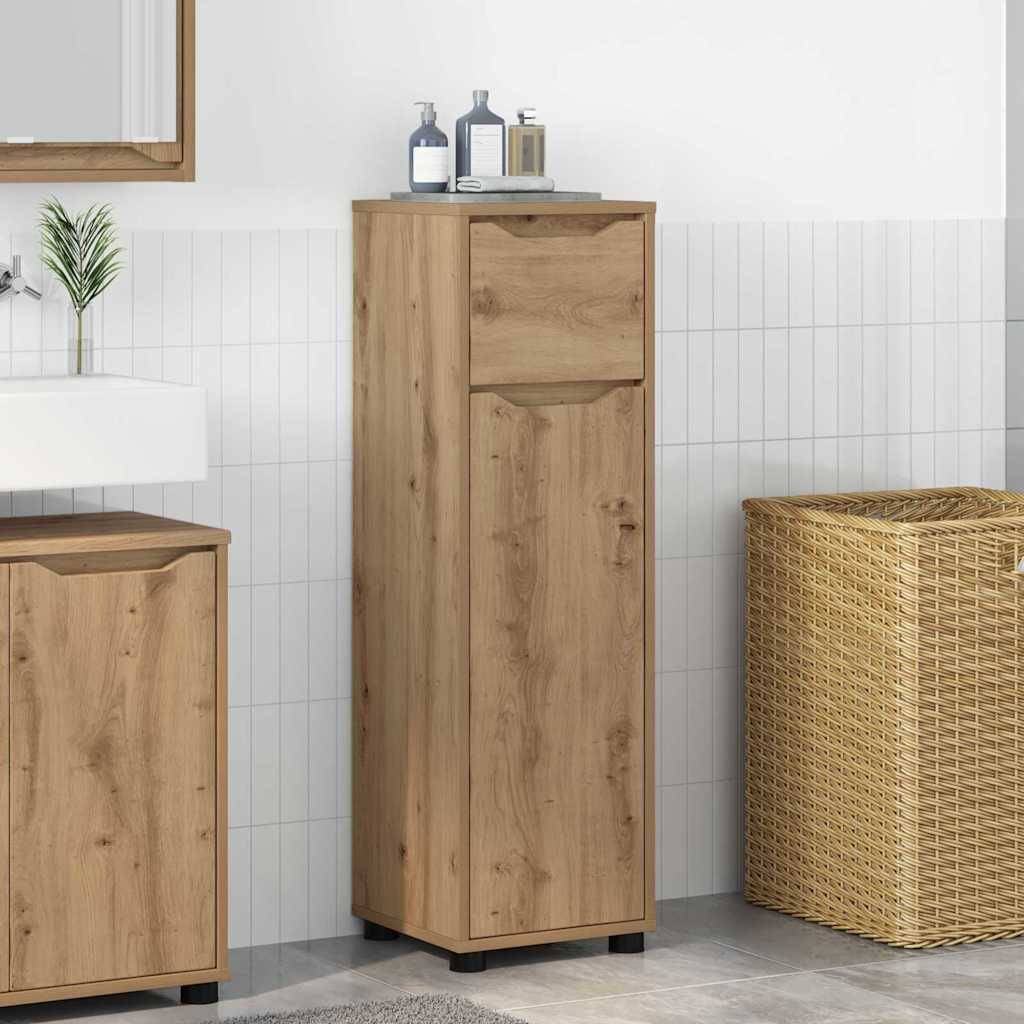 Holzbadregal mit einer oberen Schublade und einer Tür, abgebildet neben einem Waschbecken und einem Weidenkorb für Wäsche in einem gekachelten Raum.