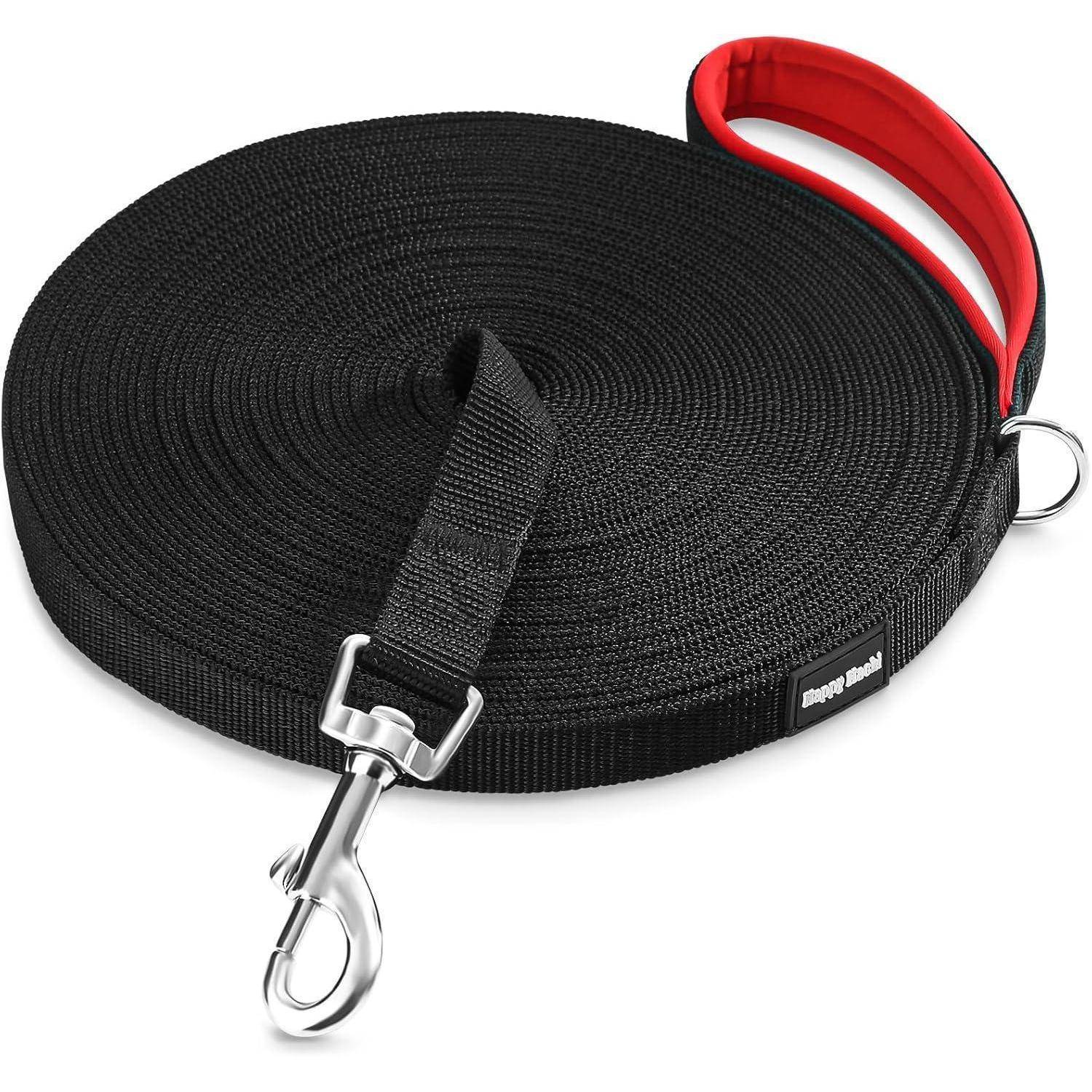 Eine lange schwarze Hundeleine aufgerollt, mit einem roten Griff und einem Metallclip an einem Ende zur Befestigung. Geeignet zum Spazierengehen oder Training mit Haustieren.
