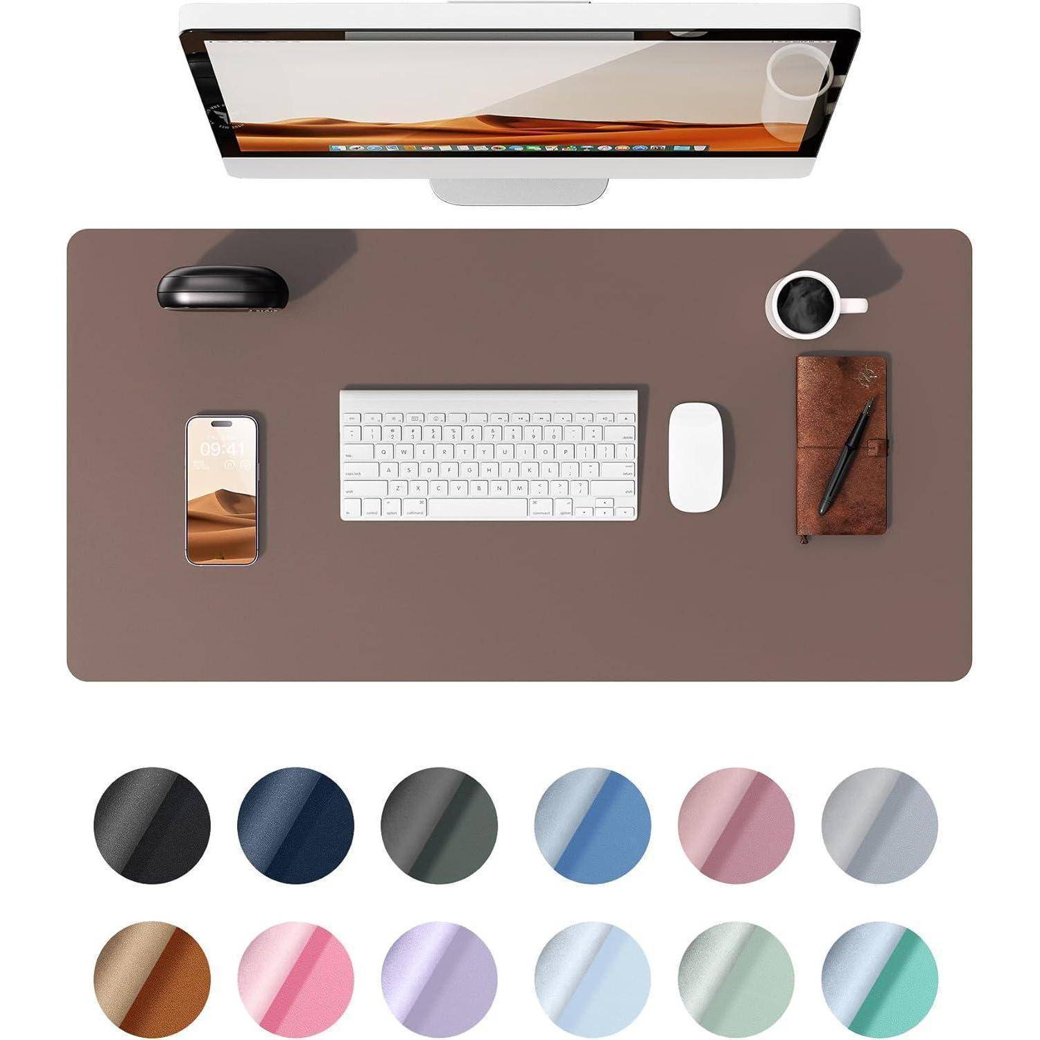 Luftaufnahme eines minimalistischen Schreibtisch-Setups mit Monitor, Tastatur, Maus, Smartphone, Notizblock und Kaffeetasse. Verschiedene Farbfelder darunter.
