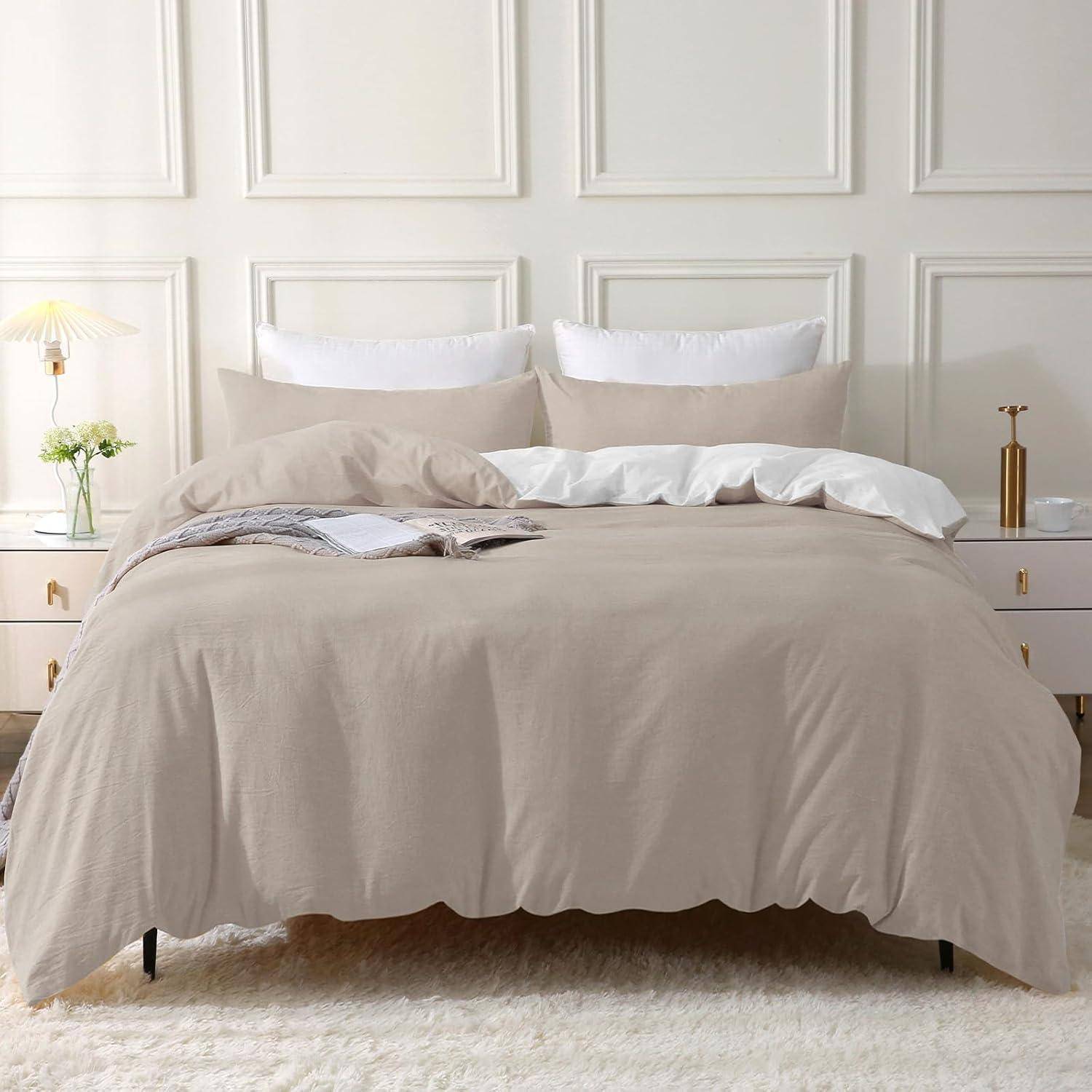 Ein ordentlich gemachtes Bett mit beigefarbener Bettwäsche, vor einer getäfelten weißen Wand, flankiert von kleinen Nachttischen mit Lampen und einer Vase mit Blumen.