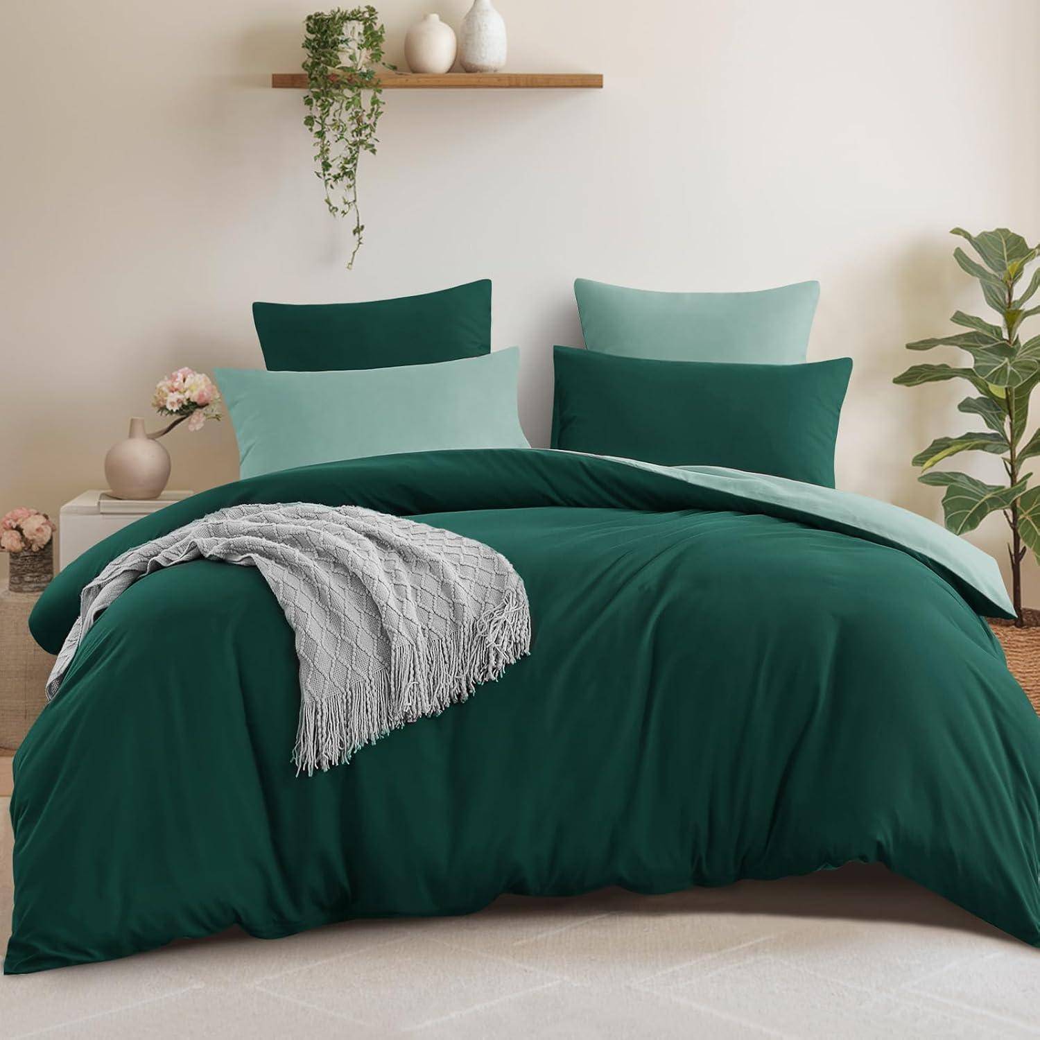 Grünes Bettwäsche-Set mit zwei Kissen und einer Kuscheldecke auf einem ordentlich gemachten Bett; hellfarben Dekorationsgegenstände auf wandmontieren Regalen.