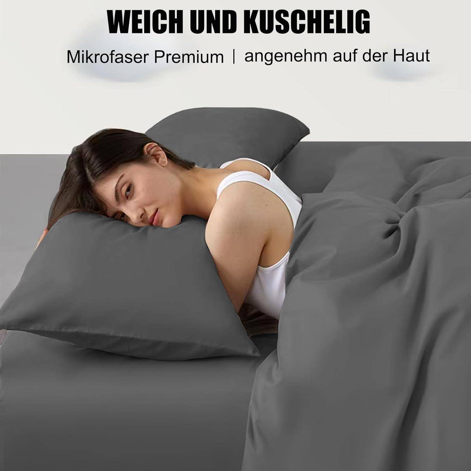 Eine Frau liegt auf einem Bett mit grauen Mikrofaserbezügen und wirkt dabei entspannt und wohl. Der Text besagt, dass die Bettwäsche 