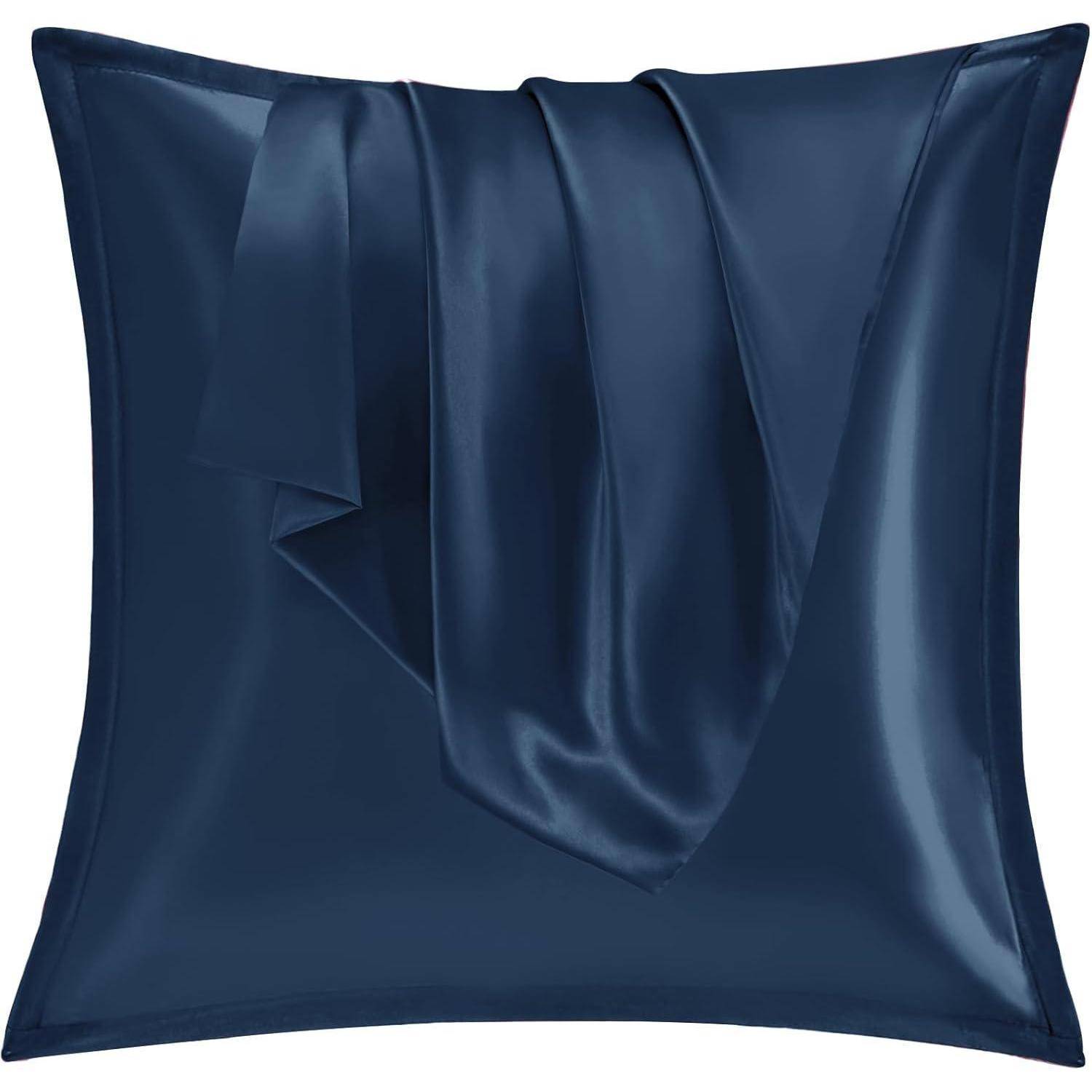 Ein marineblauer Satin-Kissenbezug mit glatter, glänzender Textur und einem passenden Seidenschal, der darüber drapiert ist.