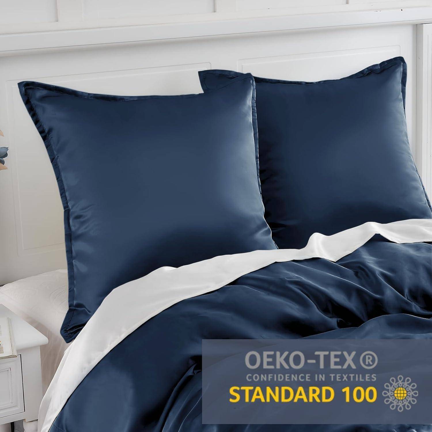 Ein ordentlich gemachtes Bett mit dunkelblauen Satin-Bettwäsche und zwei Kissen, gekennzeichnet mit der Zertifizierung 