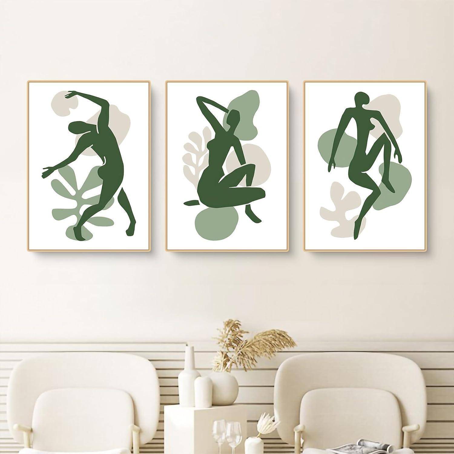 Drei abstrakte Kunstdrucke in hellen Grüntönen mit stilisierten menschlichen Figuren sind über einem minimalistischen beigen Sofa aufgehängt.