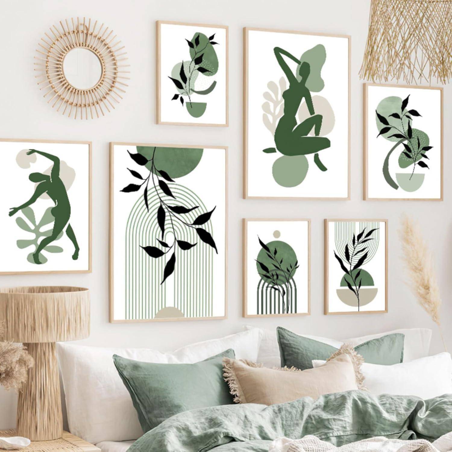 Eine Wandgalerie mit abstrakter Kunst, die grüne und beige Silhouetten und geometrische Formen zeigt. Darunter ein beiger Couchtisch mit grünen Kissen.
