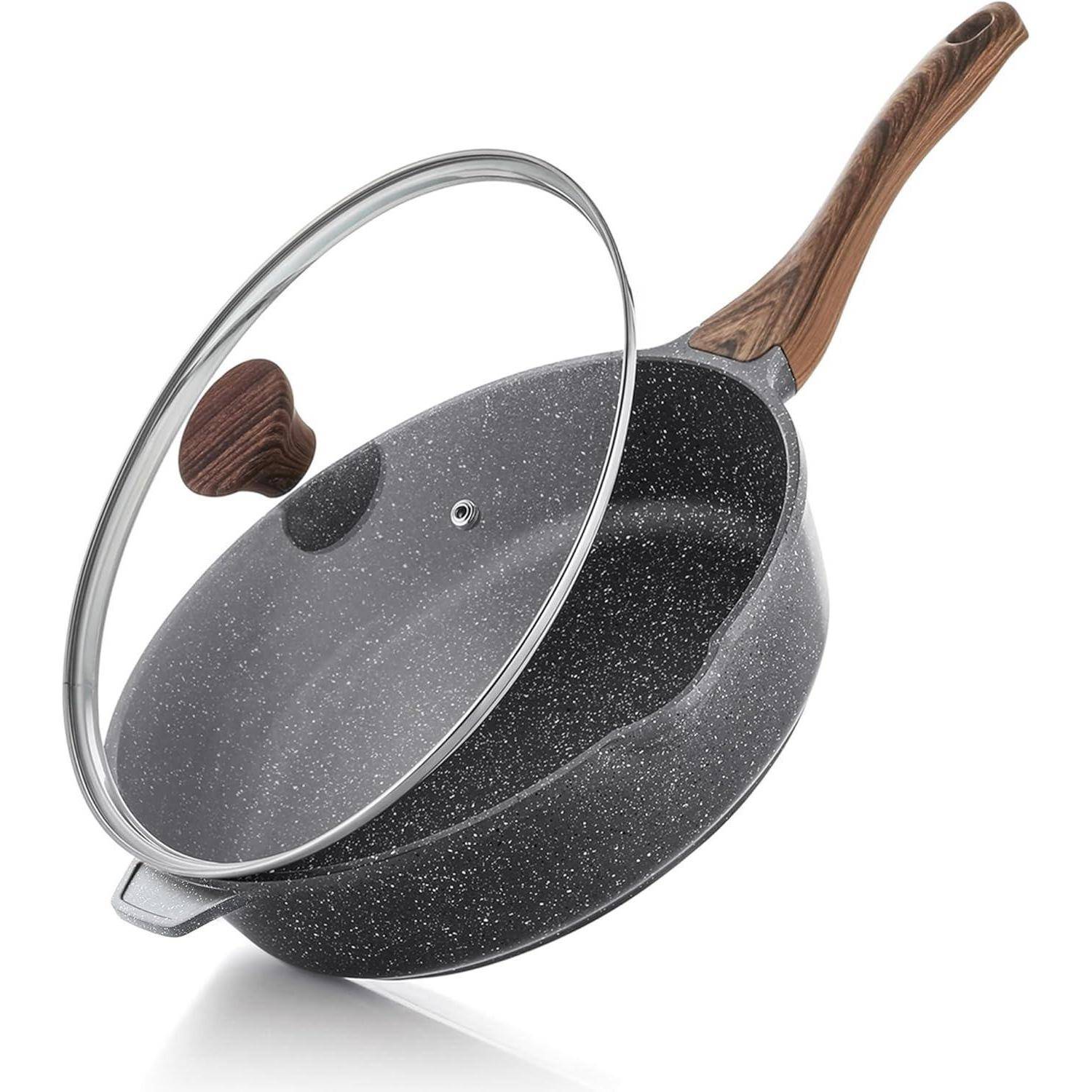 Eine Antihaft-Pfanne mit einer gesprenkelte schwarze Oberfläche und einem Holzgriff, teilweise abgedeckt von einem Glasdeckel mit einem Holzknauf.