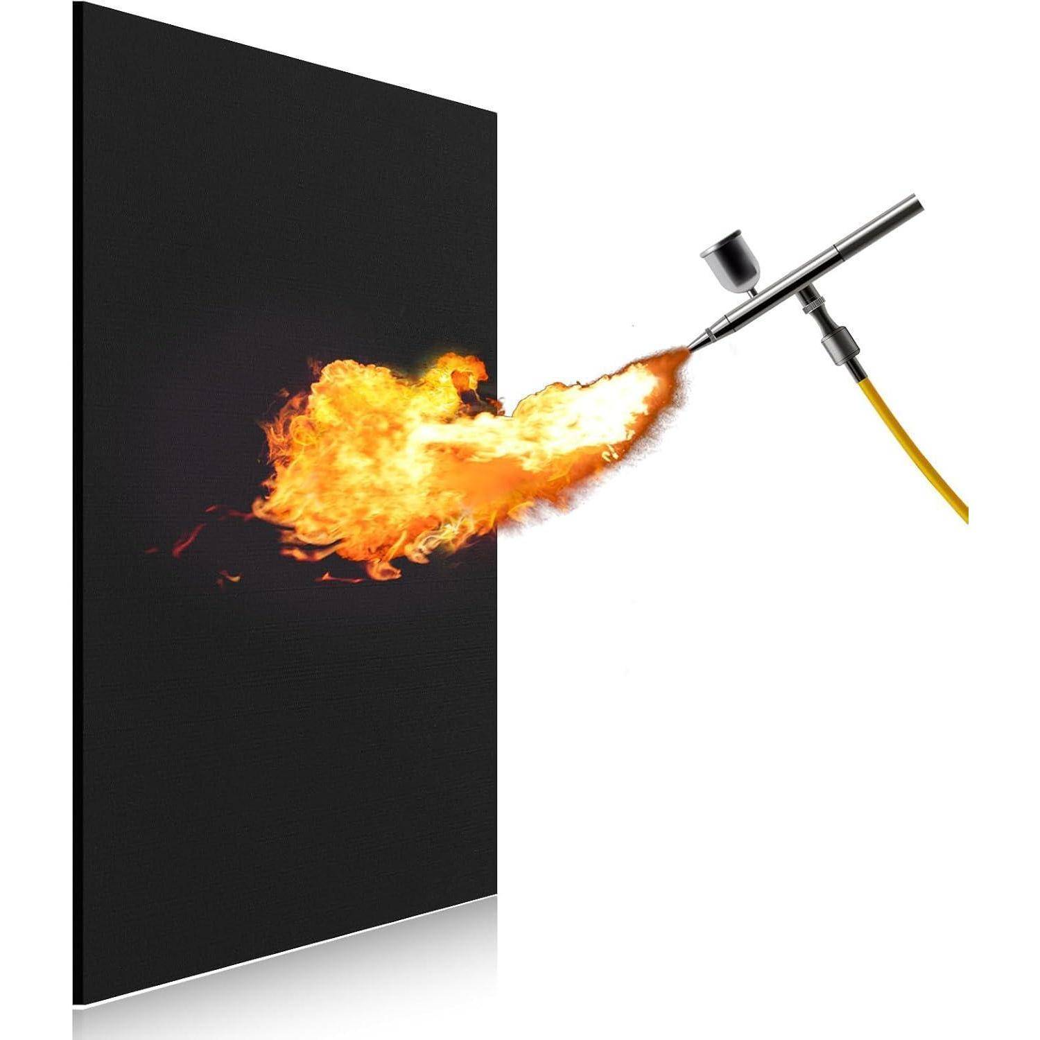 Ein Airbrush sprüht Flammen auf eine dunkle Leinwand und erzeugt einen leuchtend feurigen Effekt vor schwarzem Hintergrund.