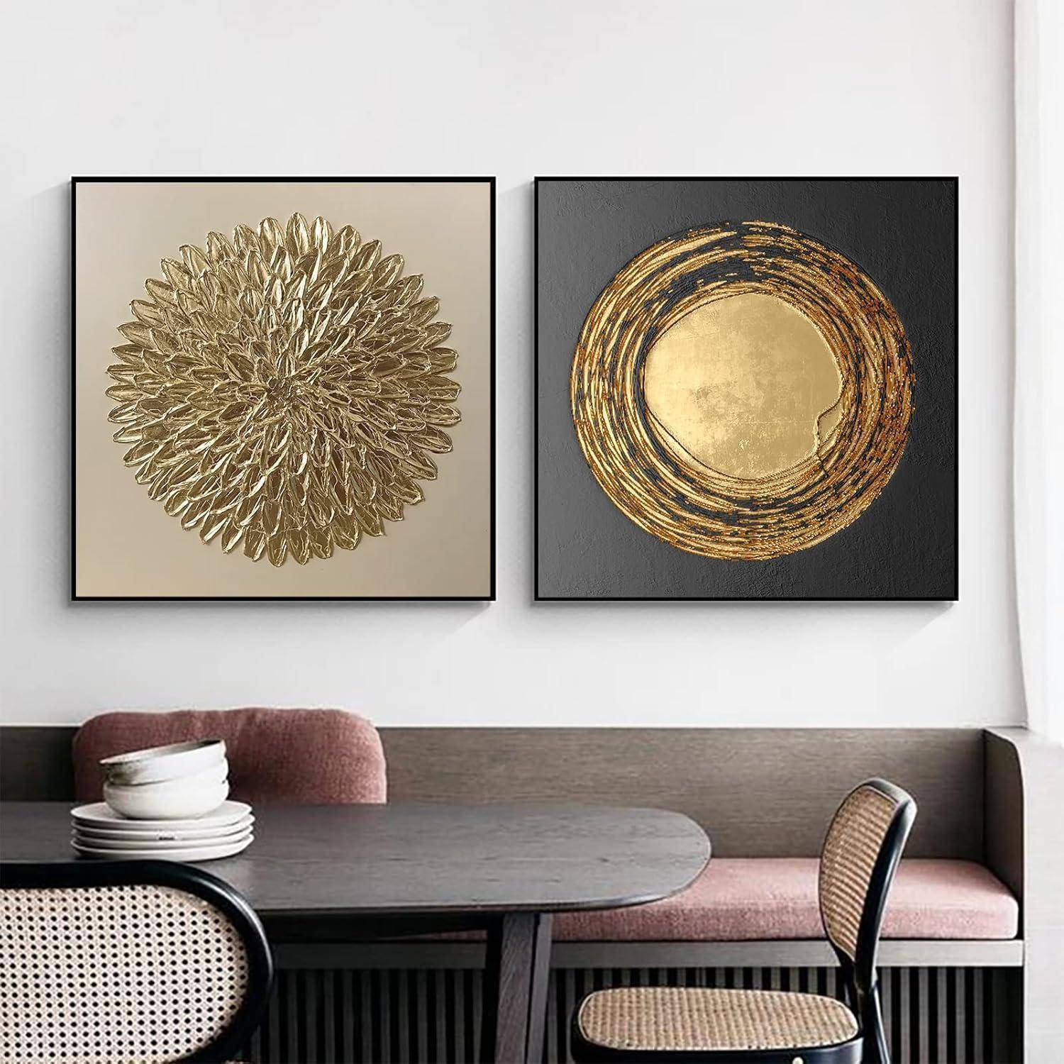 Zwei quadratische Gemälde über einer Bank: eines mit einem goldenen Kreismuster auf beigem Hintergrund, das andere mit goldenen Schwüngen auf schwarzem Hintergrund.