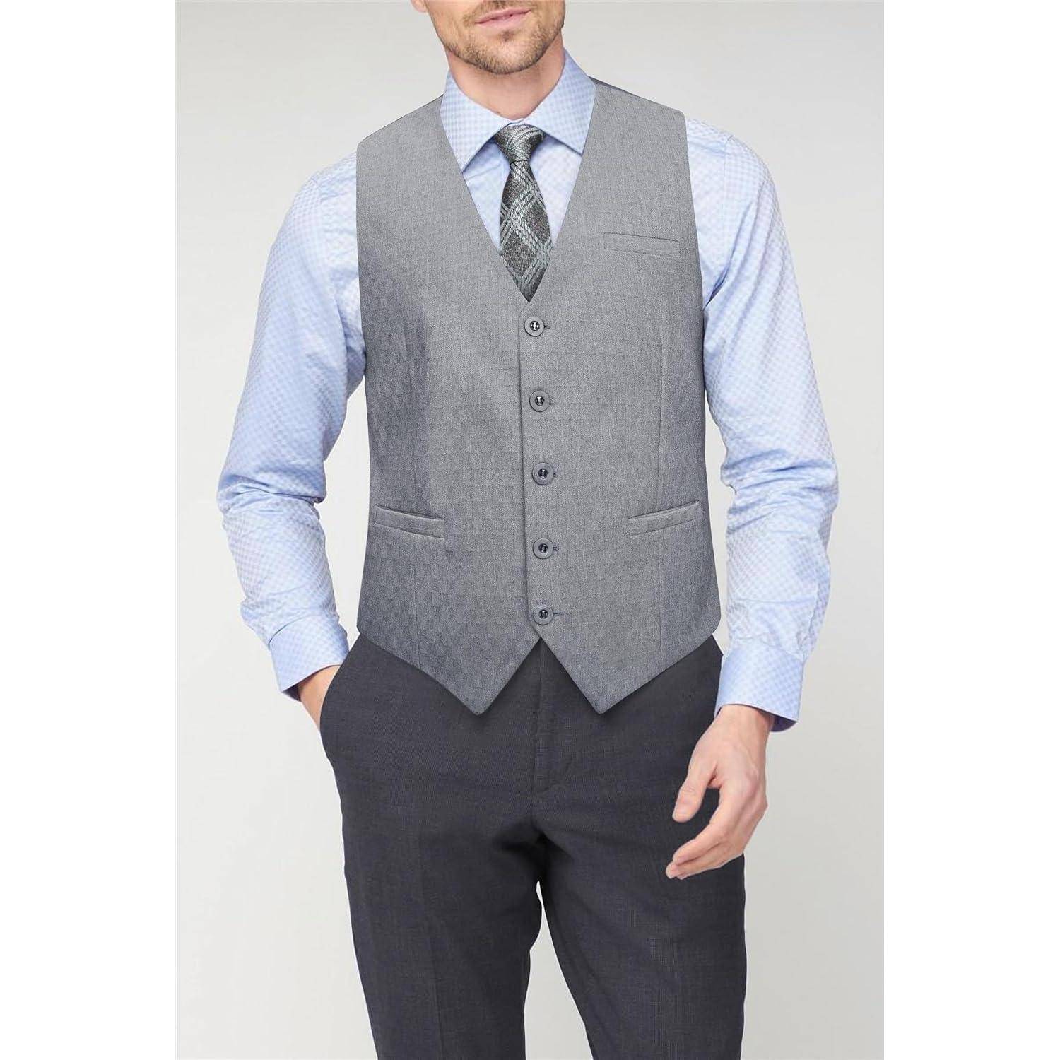 Eine Person mit einem hellblauen Hemd, grauer Weste und dunkler Krawatte, die mit in den Taschen verschränkten Händen steht und einen formellen Outfit präsentiert.