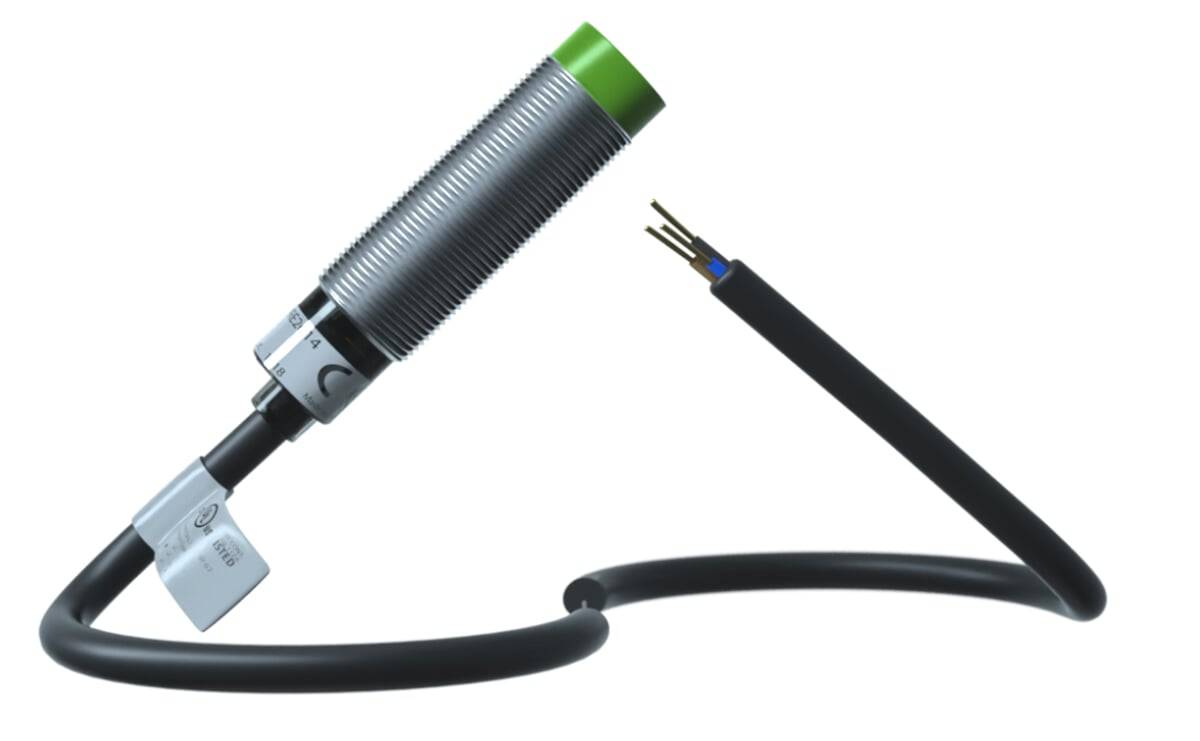 Ein zylindrischer metallischer Sensor mit einer grünen Kappe ist mit einem schwarzen Kabel mit freiliegenden Drähten verbunden, höchstwahrscheinlich Teil eines elektronischen Systems.