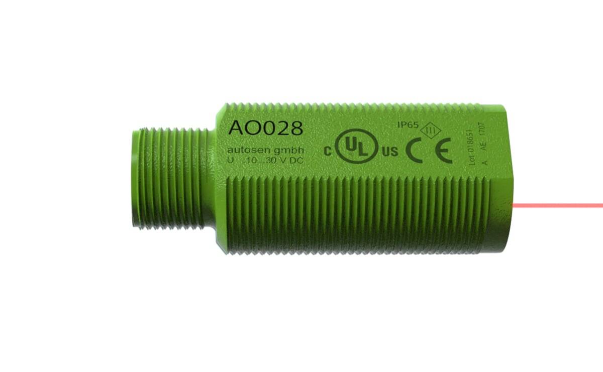Ein grüner zylindrischer Sensor mit der Bezeichnung ‚AO028', versehen mit Zertifizierungslogos, der für automatische Ausrüstung verwendet wird.