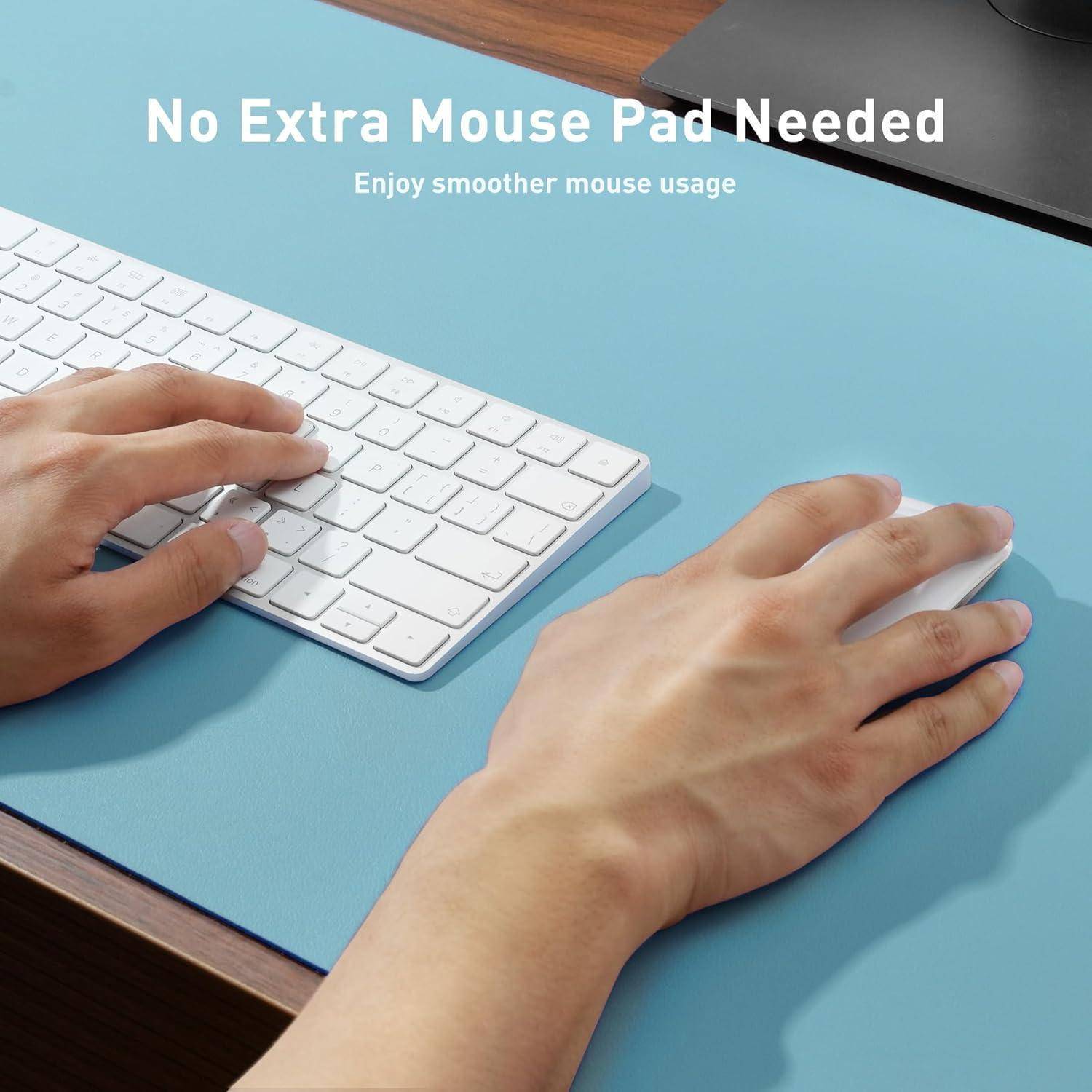 Eine Person legt seine Hände auf eine Tastatur auf einer glatten blauen Schreibtischoberfläche mit dem Text: Kein zusätzliches Mousepad benötigt. Genießen Sie eine reibungslosere Mausbewegung.