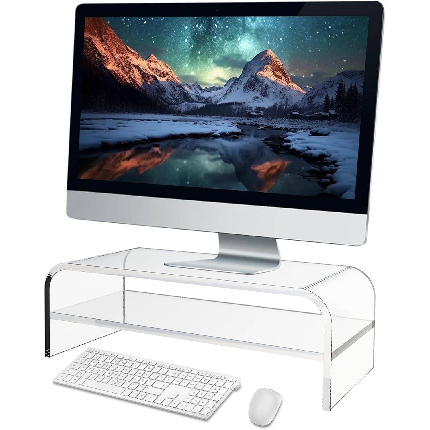 Ein Computer auf einem transparenten Ständer zeigt eine Berglandschaft. Eine Tastatur und eine Maus befinden sich davor und deuten auf eine elegante Arbeitsplatzeinrichtung hin.