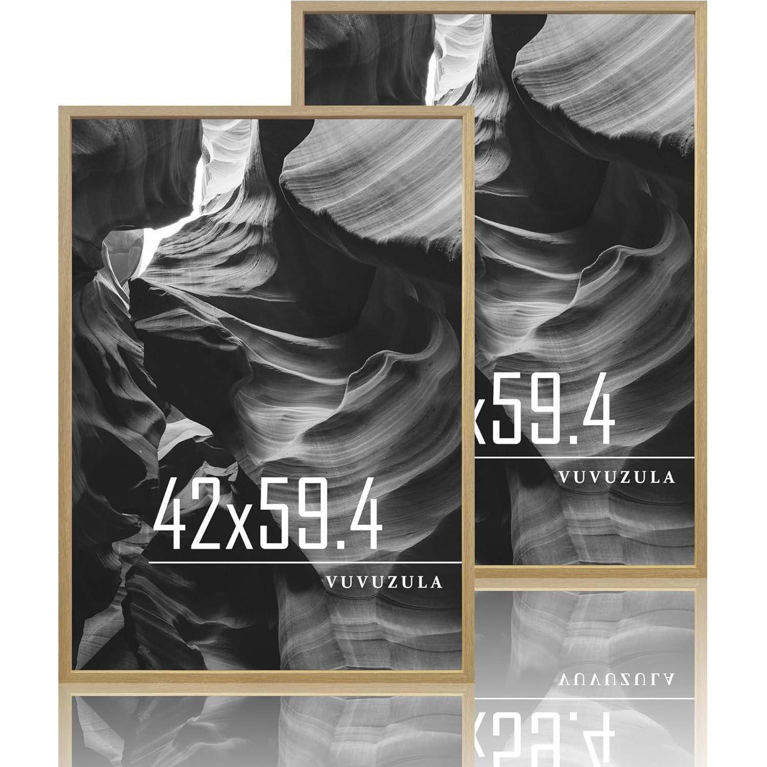 Zwei Poster zeigen ein abstraktes Wellendesign in Graustufen, beschriftet mit '42x59.4' und 'VUVUZULA', in Holzrahmen mit reflektierenden Oberflächen.