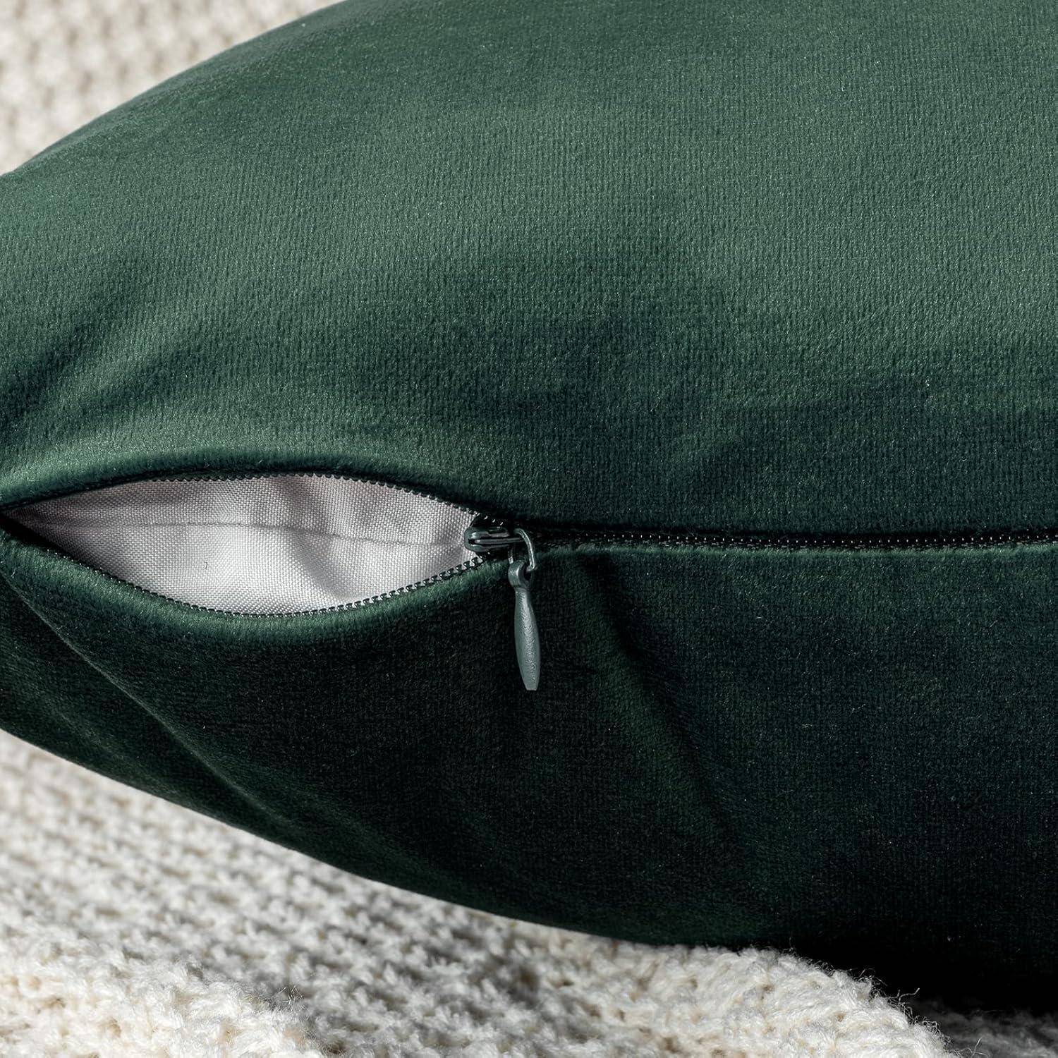 Ein dunkelgrünes Kissen mit einem leicht geöffneten Reißverschluss offenbart eine helle Innenfütterung, ruhend auf einer strukturierten beigen Oberfläche.