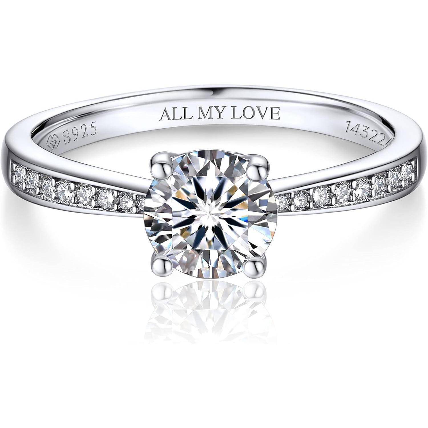 Ein eleganter Silberring mit einem großen zentralen Diamanten und kleineren Diamanten entlang des Rings. Im Inneren ist der Ring mit der Gravur 'ALL MY LOVE' versehen.