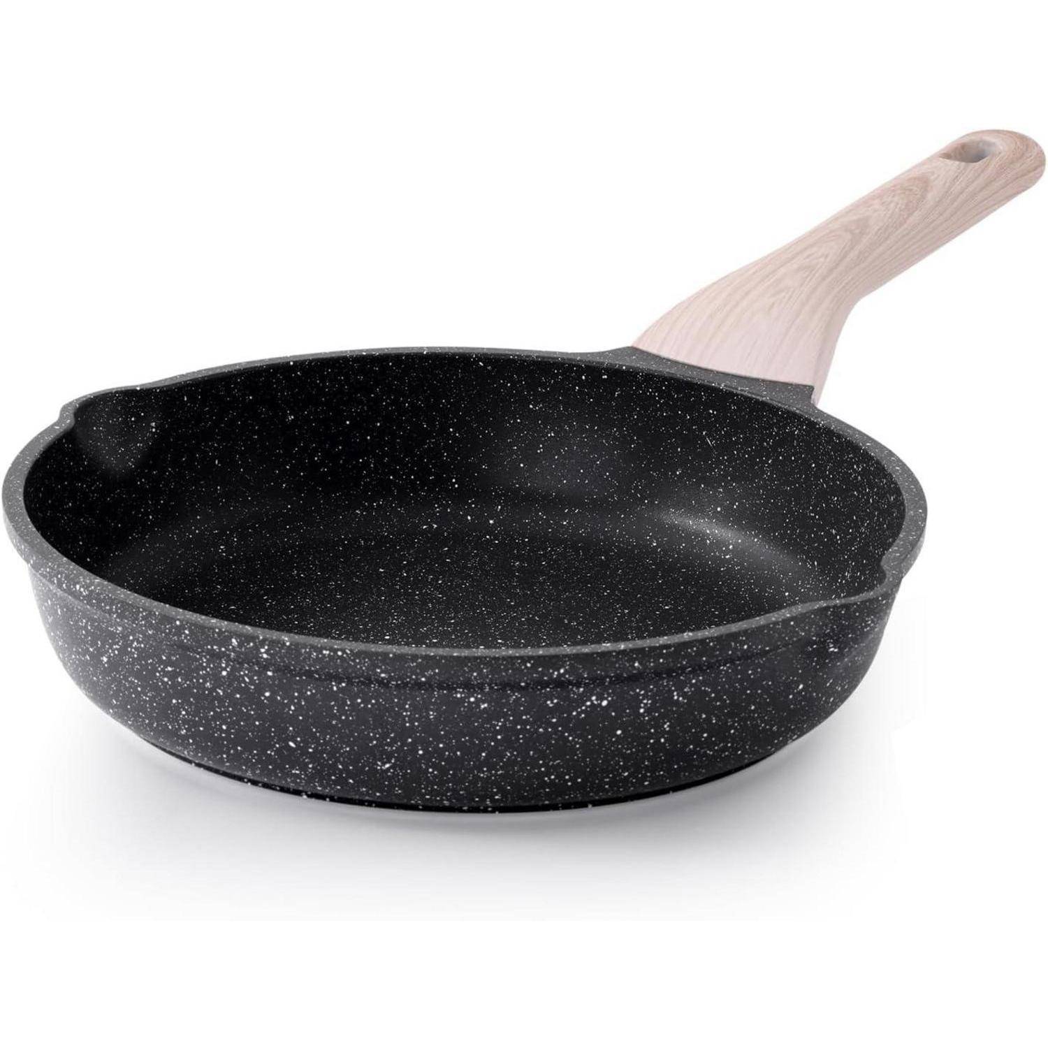 Eine schwarzgesprenkelte Bratpfanne mit helzfarbenem Griff sitzt auf einem weißen Hintergrund, konzipiert für das Kochen auf verschiedenen Herdplatten.