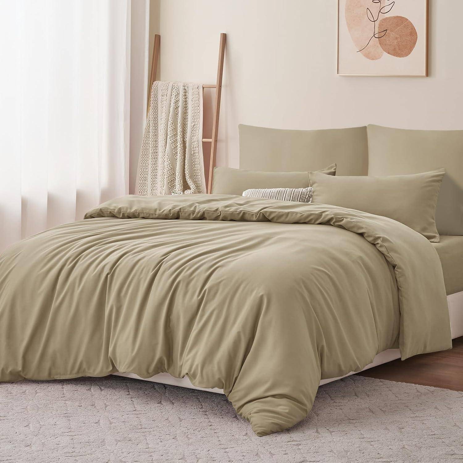Ein ordentlich gemachtes Bett mit beigefarbener Bettwäsche und Kissen in einem sanft beleuchteten Schlafzimmer. Eine Decke hängt an einer Holzleiter an einer hellen Wand.