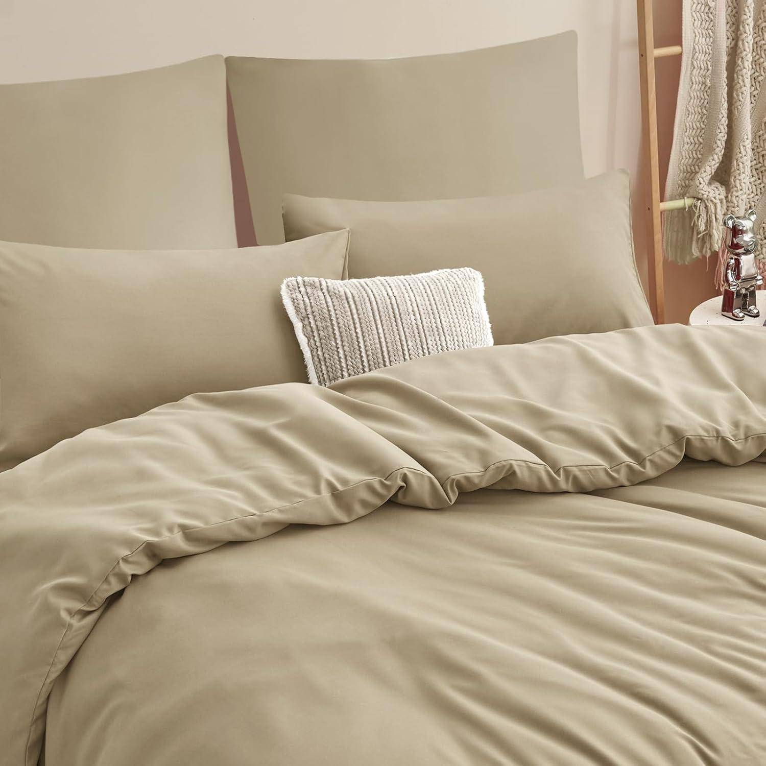 Ein beiges Bett mit strukturierten Kissen und einer weichen beigen Bettdecke, die eine gemütliche und einladende Schlafzimmeratmosphäre schafft.