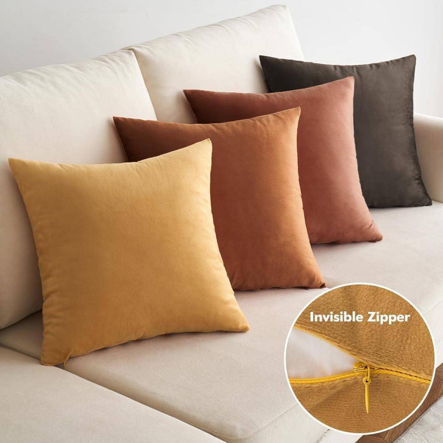 Ein Cremefarbenes Sofa mit vier Kissen in verschiedenen Farben: Beige, Rost, Senf und Braun. Die Detailaufnahme eines Kissens zeigt einen unsichtbaren Reißverschluss.