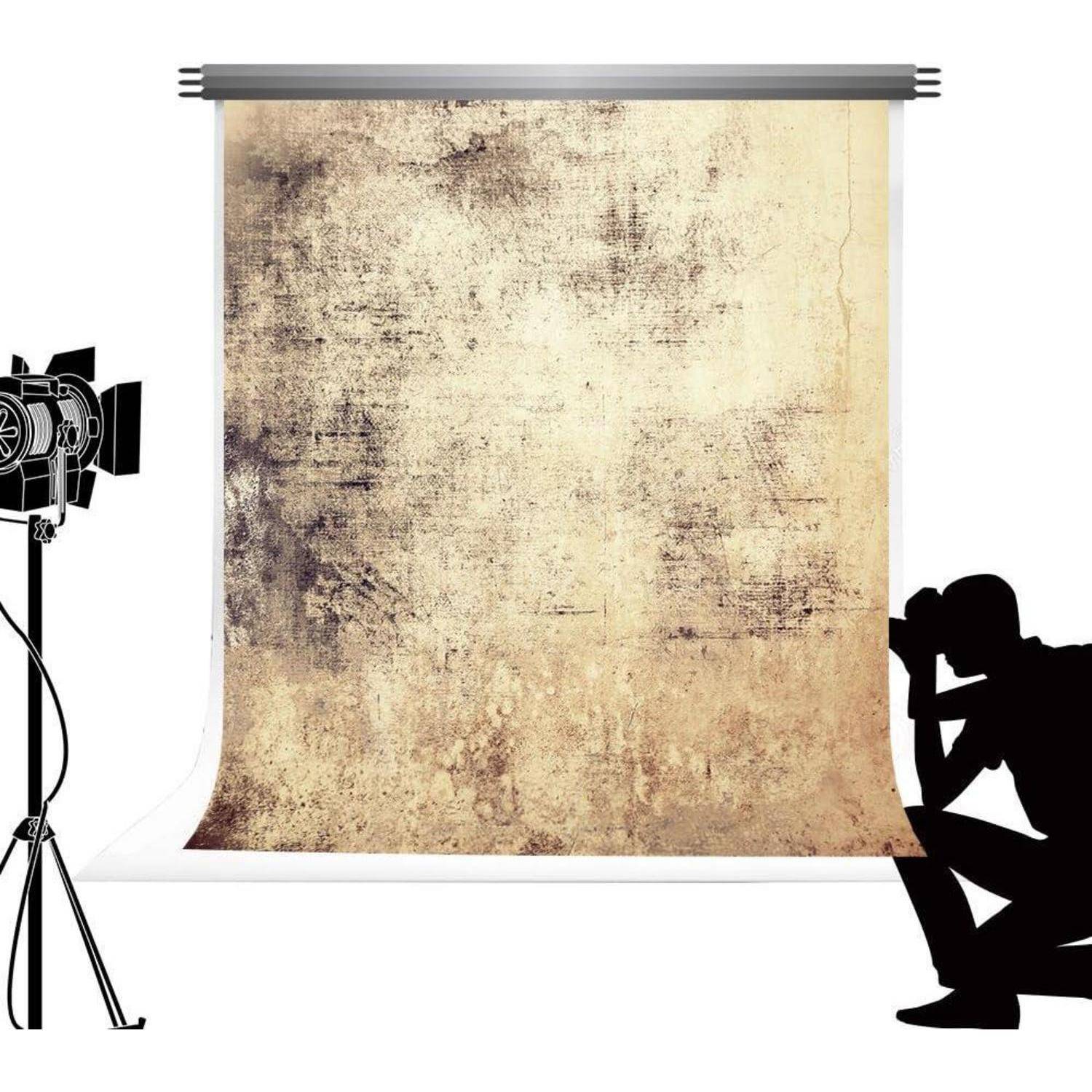 Eine Fotostudio-Szene mit einem strukturierten Hintergrund, einem schattenhaften Fotografen, der kniet, und einem Scheinwerfer auf der linken Seite.