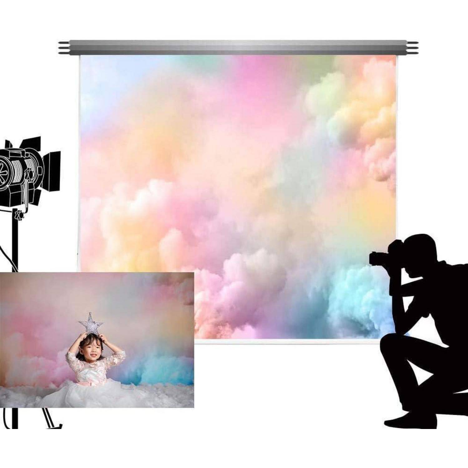 Ein Kind sitzt auf dem Boden, trägt eine Sternenkrone und ist von pastellfarbenen Wolken umgeben, aufgenommen von einem Fotografen mit Studiobeleuchtungsausrüstung.