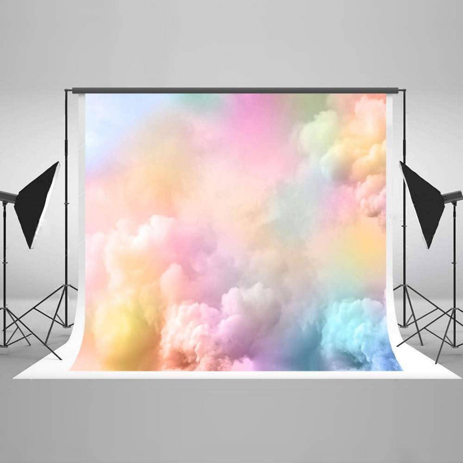 Ein Fotostudio-Setup mit einem Hintergrund, der weiche, pastellfarbene Wolken zeigt. Zwei Studioblitzleuchten sind auf beiden Seiten positioniert.