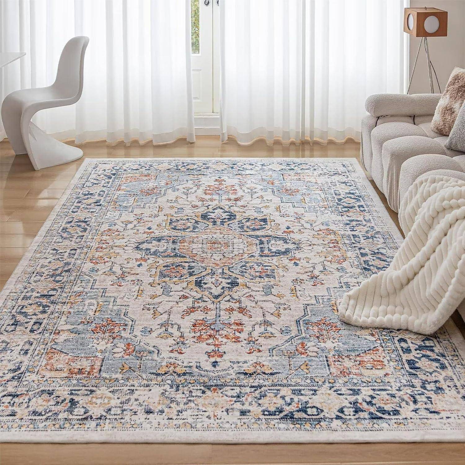 Ein Wohnzimmer mit einem großen gemusterten Teppich, einem weißen modernen Stuhl, einem gemütlichen grauen Sofa und transparenten Gardinen, die natürliches Licht hereinlassen.