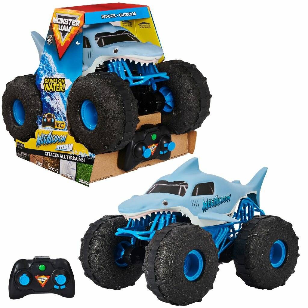 Ein Spielzeug-Monstertruck mit Haidesign, ausgestattet mit großen Reifen, in einer Verpackung mit der Aufschrift "Greift alle Gelände an"". Eine Fernbedienung ist enthalten.