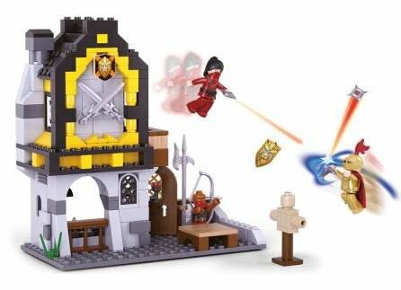 Eine Spielszene, die eine Fassade eines mittelalterlichen Burggrundriss mit Spielfiguren zeigt, die sich in einem Kampf mit Laserwaffen befinden und dabei kreatives Spiel demonstrieren.