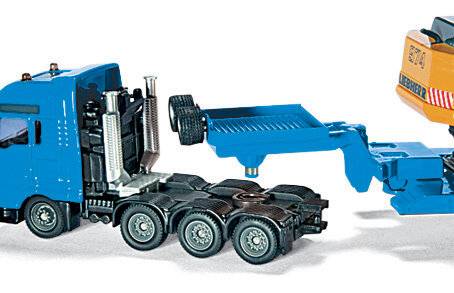 Ein blauer Spielzeug-Lastwagen mit einem Flachbett-Anhänger, ausgestattet mit sechs Rädern und verchromten Auspuffrohren, auf weißem Hintergrund platziert.