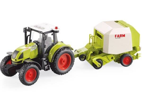 Ein grüner Spielzeugtraktor mit roten Rädern zieht einen passenden landwirtschaftlichen Anhänger mit der Beschriftung 