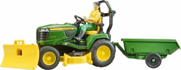 Eine Spielzeugfigur einer Person, die auf einem grünen John Deere-Traktor mit großen gelben Rädern sitzt. Die Figur trägt ein gelbes Hemd und grüne Hosen und hält das Lenkrad.