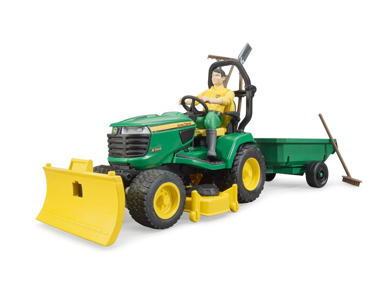 Ein Spielzeugmodell eines grünen Traktors mit einem gelben Pflug und einem Anhänger. Eine Spielzeugfigur sitzt auf dem Fahrersitz und hält das Lenkrad.
