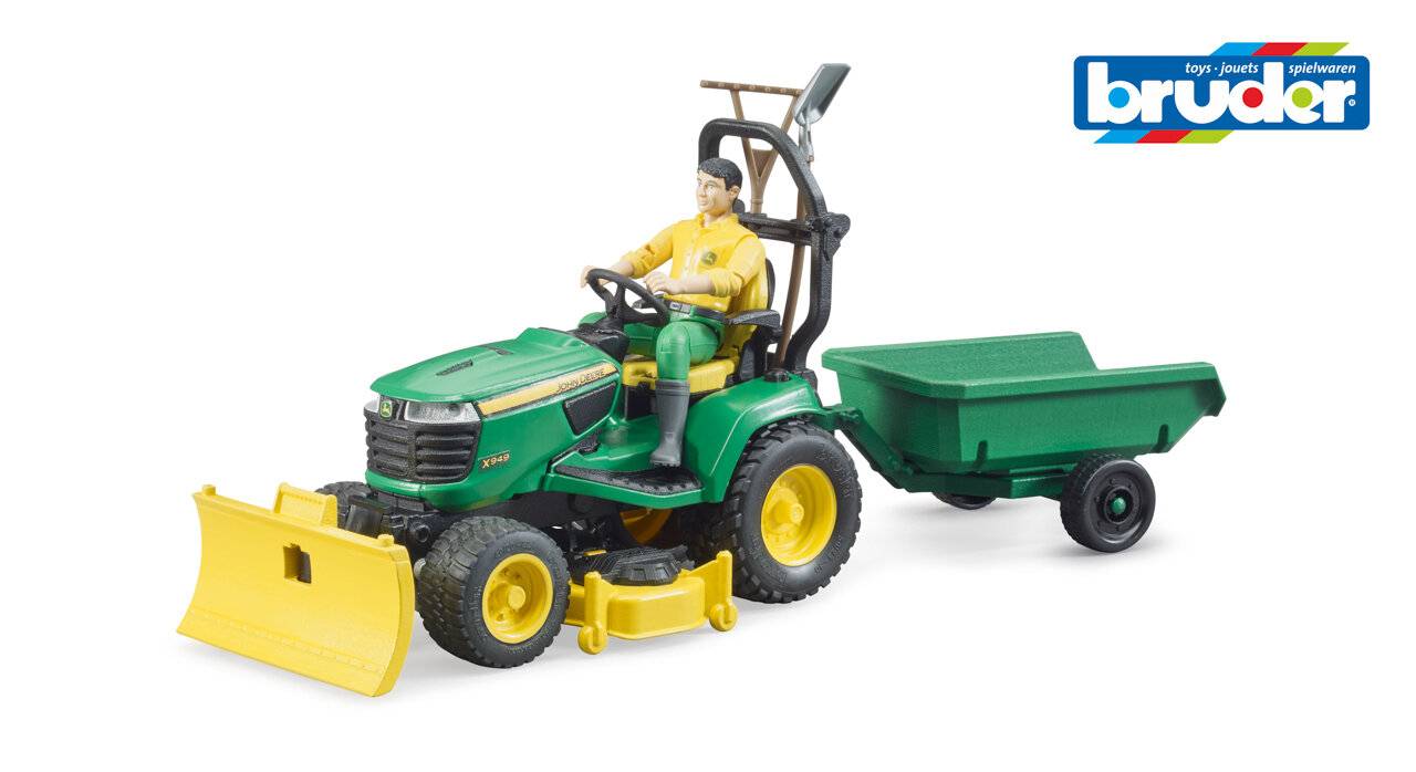 Ein Spielzeugmodell eines grünen Nutztraktor mit einem Schneepflug und Anhänger; eine Figur sitzt auf dem Fahrersitz und demonstriert landwirtschaftliche Ausrüstung.