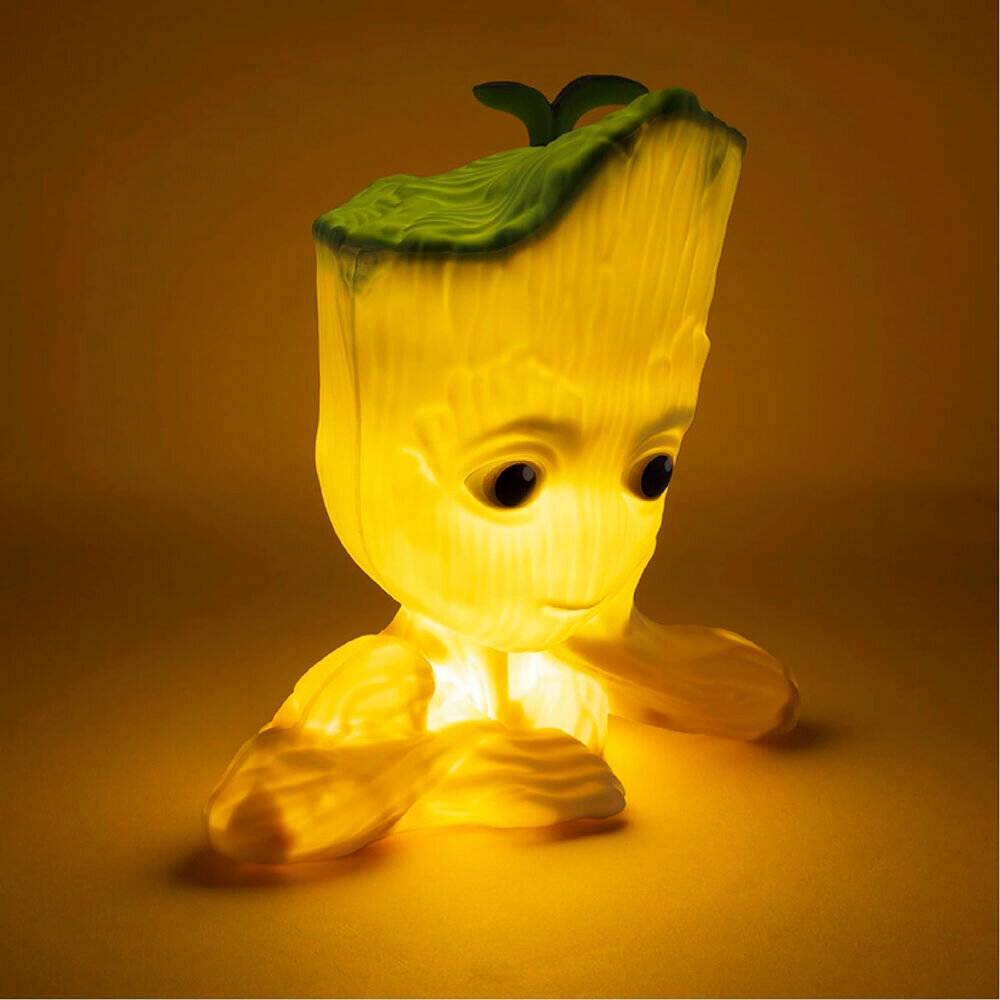 Eine leuchtende, cartoonhafte Pflanzenfigur mit einem grünen Kopf, der einem Haar ähnelt, großen Augen und sitzender Haltung, strahlt ein warmes gelbes Licht in einer gedämpften Umgebung.