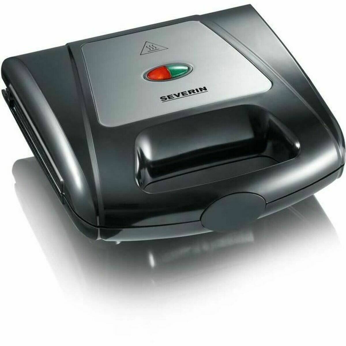 Ein schwarz-silberner Sandwichmaker mit Kontrolleuchten oben, die eine grüne und eine rote Lampe zeigen, und einem Griff zum Pressen von Sandwiches.